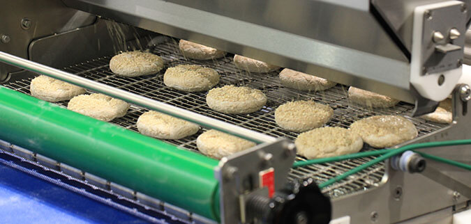 Commercial conveyor oven baking food products in an industrial kitchen