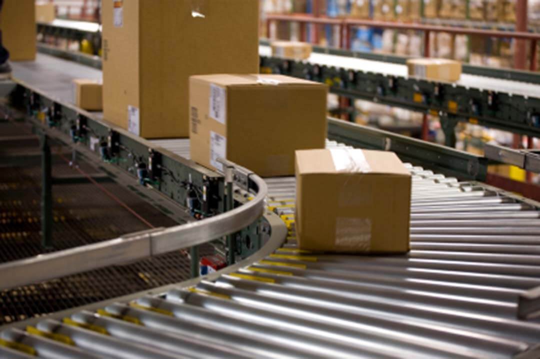 Conveyor system moving packaged goods in a factory production line