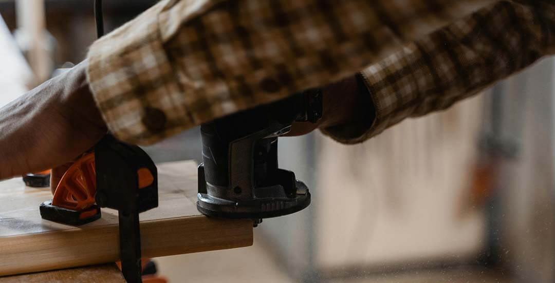 Person working on a woodworking project using a power tool
